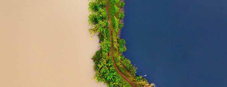 Imagem exibindo faixa de areia e rio